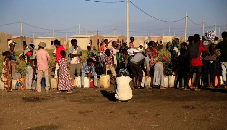 لاجئون إثيوبيون يصطفون للحصول على المياه في مخيم فاشاغا بالسودان - رويترز