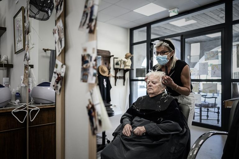 حلاق فرنسي يقص شعر أحد الزبائن