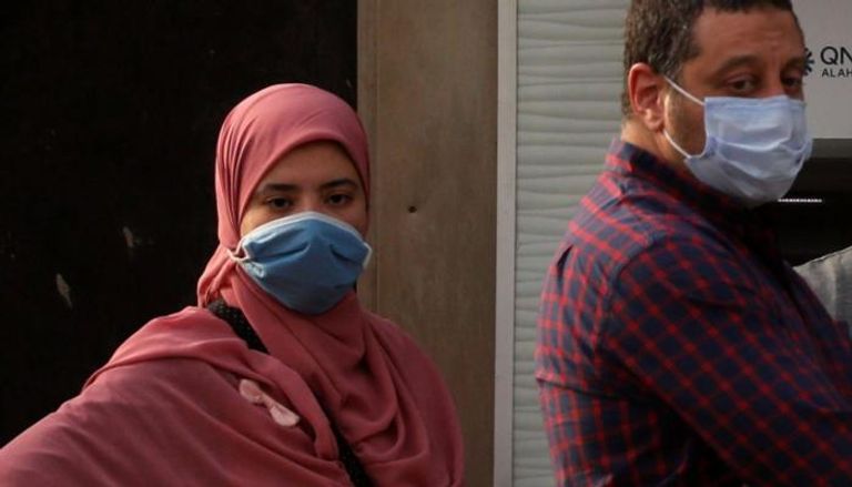 مصريان يرتديان كمامتين للوقاية من فيروس كورونا