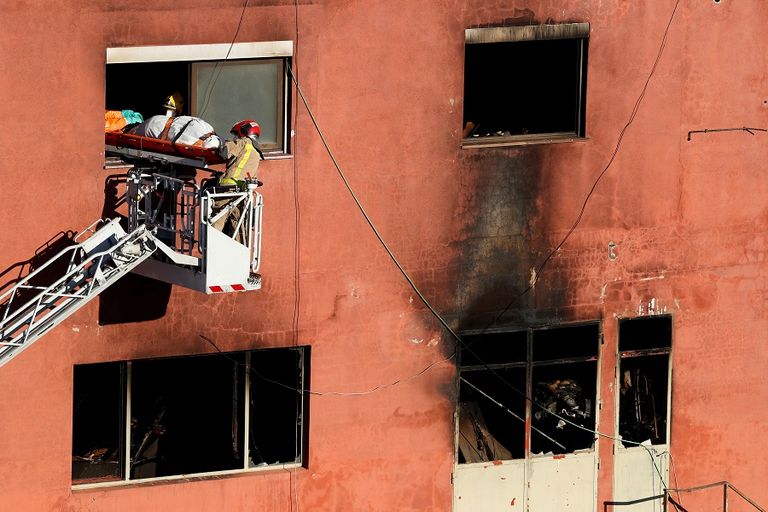 قوات الإنقاذ تنقل إحدى ضحايا الحريق