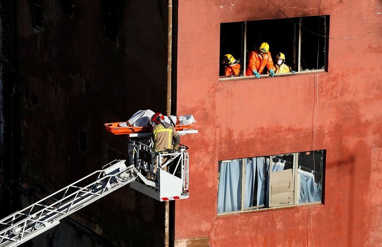 قوات الإنقاذ تنقل إحدى ضحايا الحريق