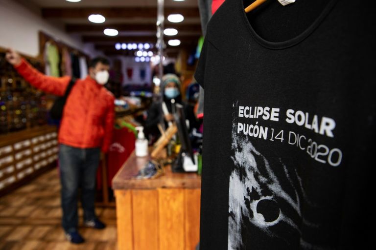 رجل يعبر بالقرب من لوحة إعلانية عن نظارات خاصة لمشاهدة الكسوف الكلي للشمس بتشيلي