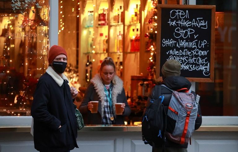 شخص يرتدي الكمامة أمام مسرح ترافالجار في لندن