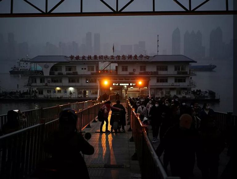 أشخاص يرتدون كمامات يخرجون من عبارة بعد عبورهم نهر انغتسي عند الغسق بعد عام تقريبًا من تفشي مرض فيروس كورونا (كوفيد-19)، مقاطعة هوبي، الصين 11 ديسمبر 2020 2020 - رويترز شابة صينية بووهان تعدل من مكياجها في المطعم بمناسبة عيد ميلادها - رويترز