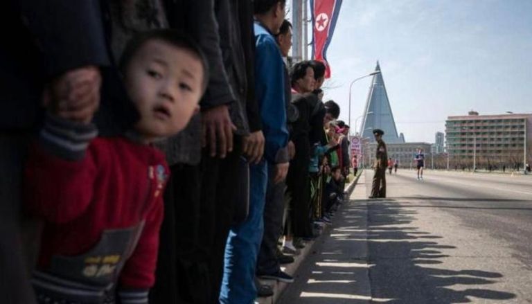 مواطنون يصطفون على جانب الطريق في كوريا الشمالية