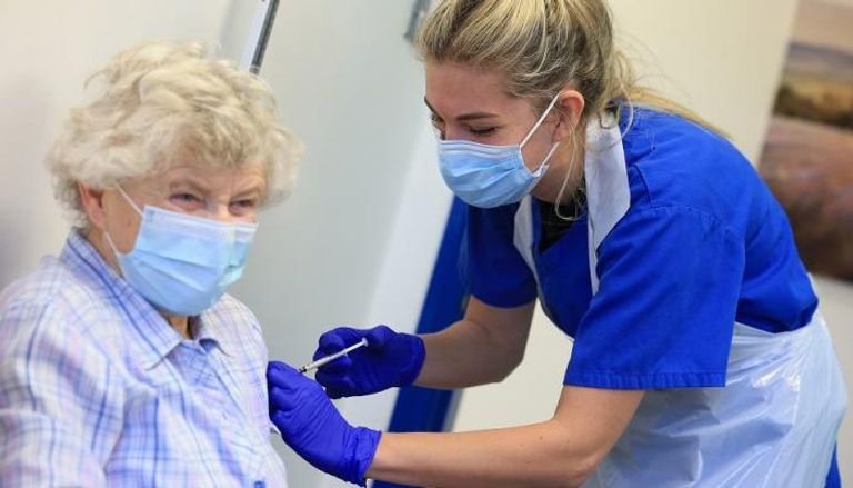 ممرضة تمنح لقاح فايزر لمسنة بريطانية