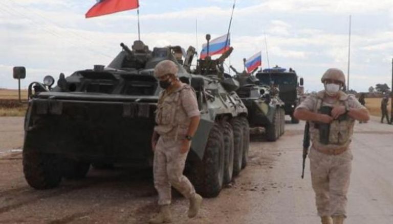 قوات روسية يوفرون الحماية لأحد الطرق في سوريا