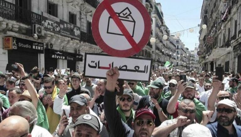 جزائريون يرفعون لافتة بها مطالب إنهاء تزوير الانتخابات - أرشيفية