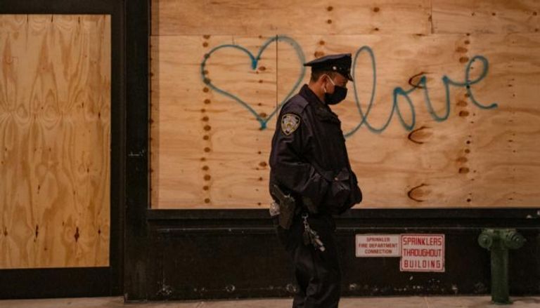 شرطي أمام واجهة محل عليها رسم جرافيتي في نيويورك  