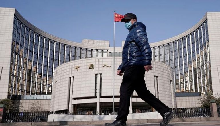 صورة لعابر  أمام البنك المركزي الصيني - رويترز