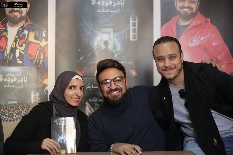 شباب يعملون بأجر للترويج لبعض الكتب بمعرض القاهرة