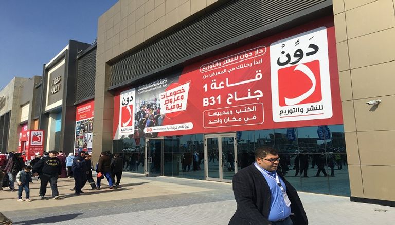شباب يعملون بأجر للترويج لبعض الكتب بمعرض القاهرة