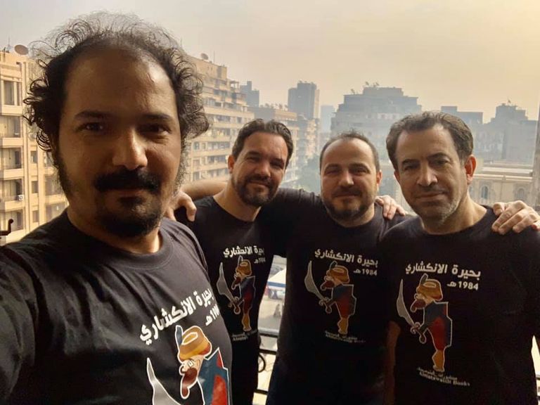 شباب يعملون بأجر للترويج لبعض الكتب بمعرض القاهرة