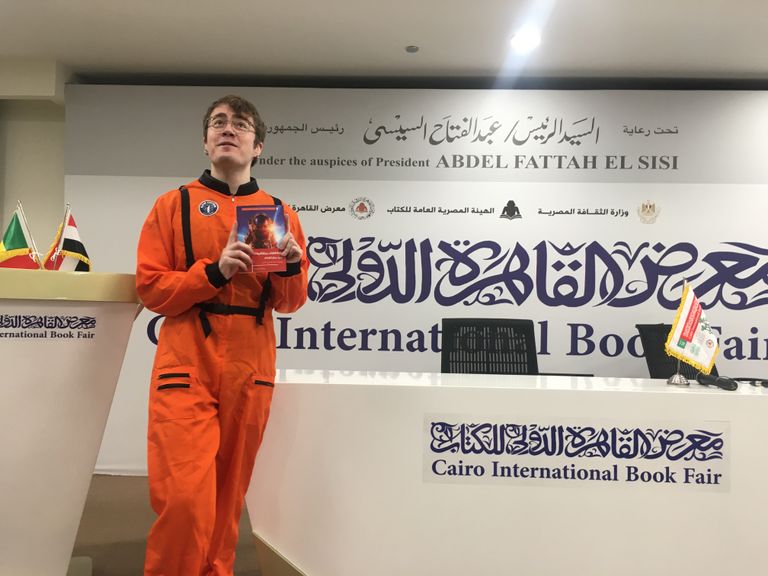 شباب يعملون بأجر للترويج لبعض الكتب بمعرض القاهرة