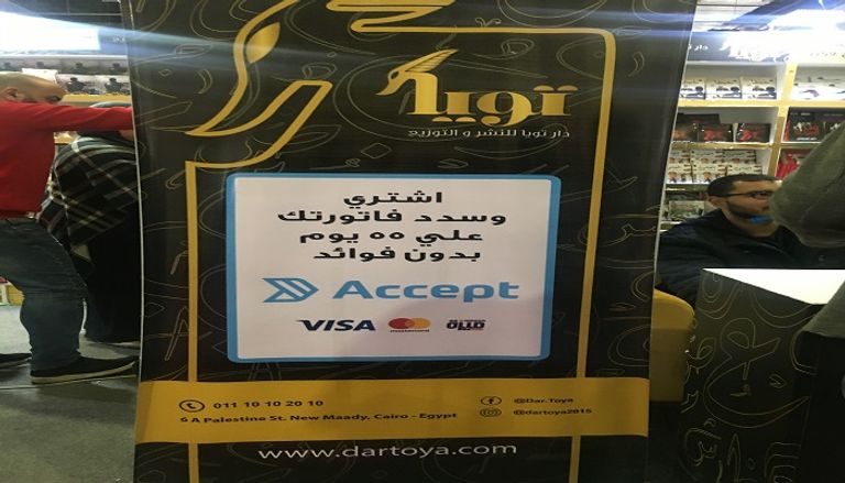 شباب يعملون بأجر للترويج لبعض الكتب بمعرض القاهرة