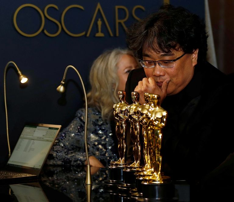 تايكا وايتيتي يحمل الأوسكار وخلفه كارتو نيل يضحك