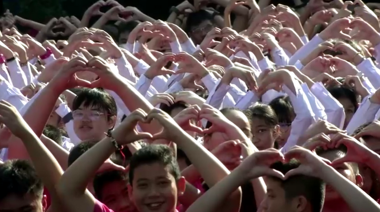 الطلبة تجمعوا وبرفقتهم زوج من الفيلة ليصنعوا شكل قلب 