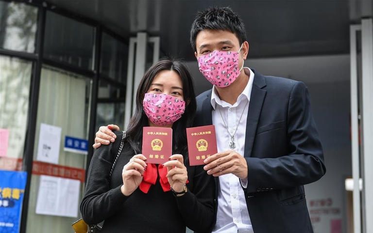 زوجان صينيان يحتفلان بعد إتمام إجراءات الزواج خلال تفشي فيروس كورونا الجديد وجبات جاهزة مجانية لأكثر من 200 عامل طبي في مستشفى لعلاج كورونا بالصين