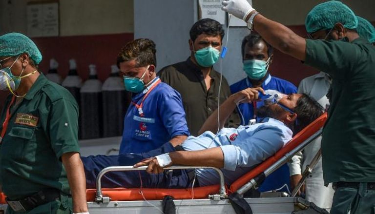 مسعفون ينقلون مريضاً إلى المستشفى بعد واقعة تسرب الغاز