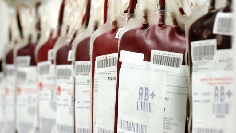 فريق طبي يرتدي الملابس الواقية أثناء الكشف على حالة مصابة بكورونا الجديد