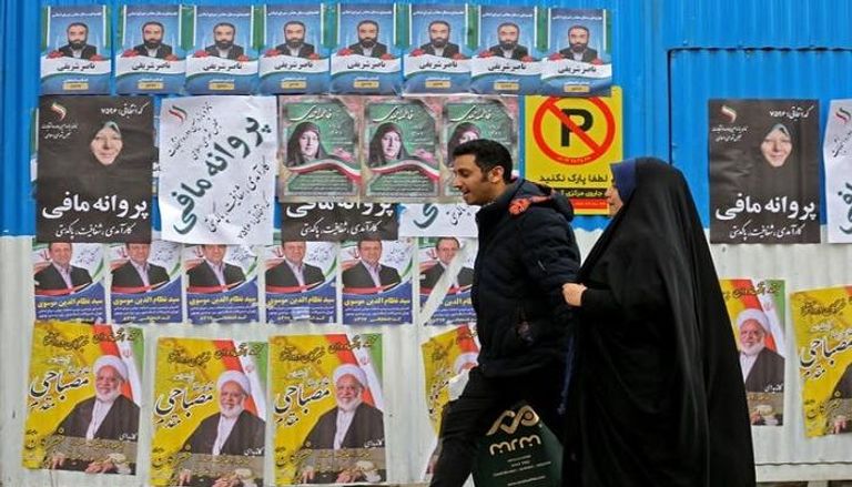 إيرانيون أمام ملصقات دعائية لمرشحين