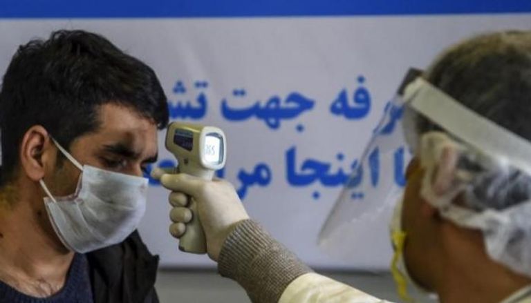 طبيب إيراني يفحص أحد المصابين 