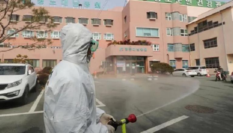 مسؤول صحة بكوريا الجنوبية ينشر مواد مطهرة أمام مستشفى بسبب كورونا