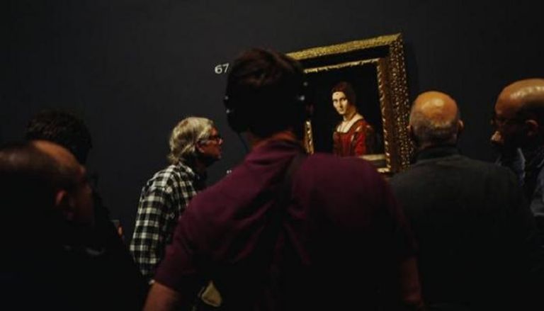 زوار المعرض يشاهدون أحد الأعمال الفنية