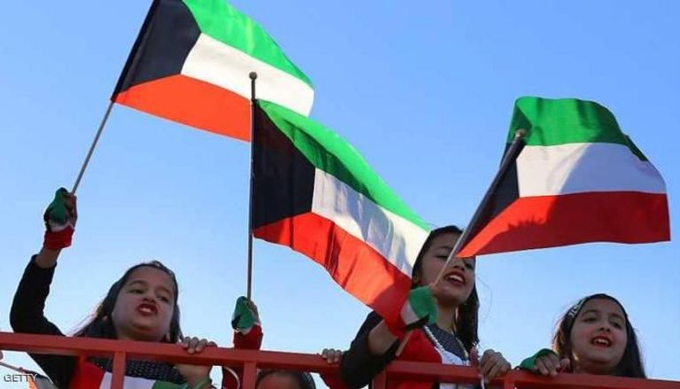 أطفال كويتيون يرفعون علم بلادهم