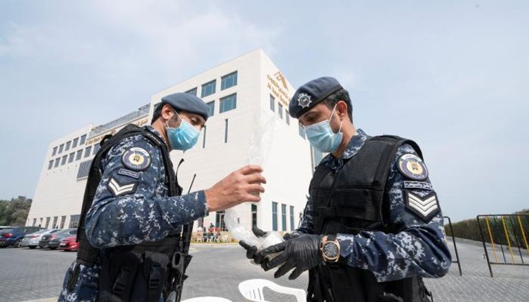 رجال أمن كويتيون عند فندق احتجاز الحالات المشتبهة بين العائدين من إيران