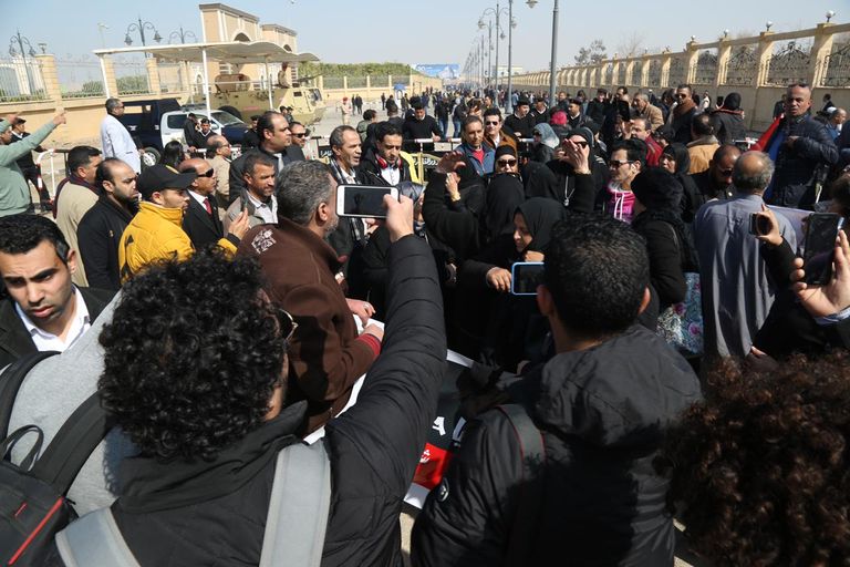 مصري يحمل صورة مبارك أمام المسجد الذي ستقام به صلاة الجنازة