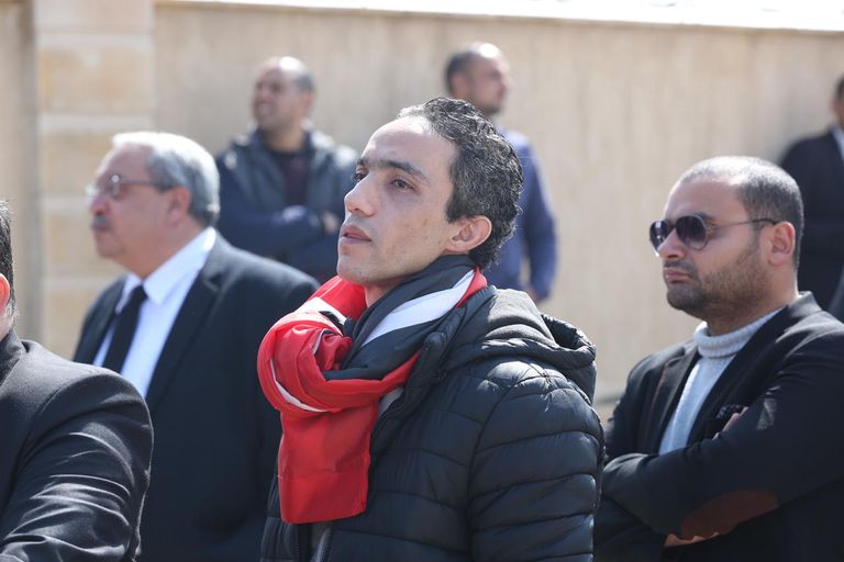 مصري يحمل صورة مبارك أمام المسجد الذي ستقام به صلاة الجنازة