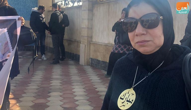 مصري يحمل صورة مبارك أمام المسجد الذي ستقام به صلاة الجنازة