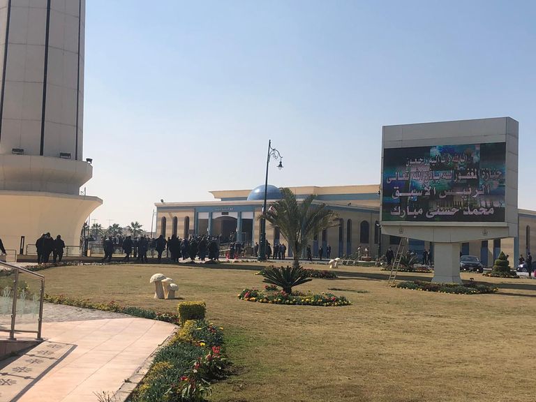 مصري يحمل صورة مبارك أمام المسجد الذي ستقام به صلاة الجنازة