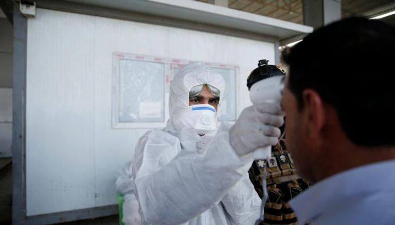 طبيب يجري فحوصات فيروس كورونا على عراقي في مدينة الموصل
