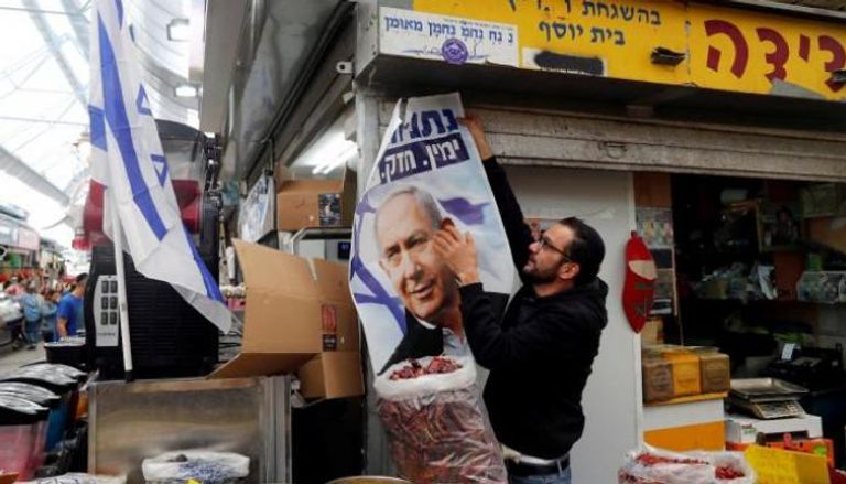 إسرائيلي يعلق لافتة دعائية لنتنياهو - أرشيفية