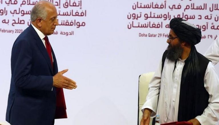 المفاوض الأمريكي زلماي خليل زاد والقيادي بطالبان الملا عبدالغني برادر الرئيس الأفغاني أشرف غني