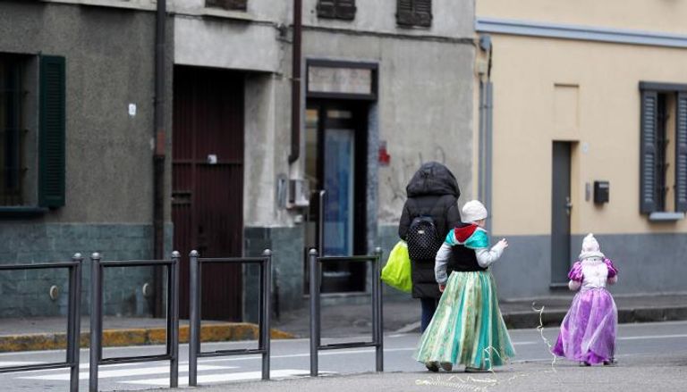 سيدة وطفلتان في أحد شوارع مدينة صغيرة بالقرب من ميلانو