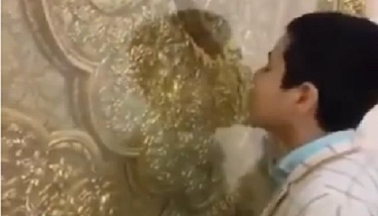 شخص مجهول يقبل ضريحا في إيران