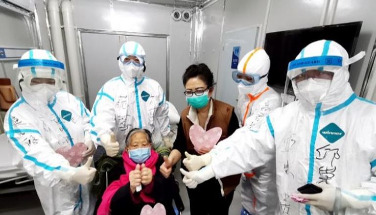 عجوز وابنتها وأطباء يلتقطون صورة في أحد مستشفيات ووهان - تشاينا ديلي