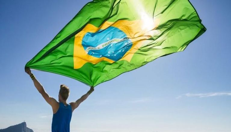 رجل يحمل علم دولة البرازيل