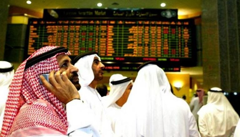 متعاملون يتابعون الشاشات داخل سوق الإمارات للأوراق المالية