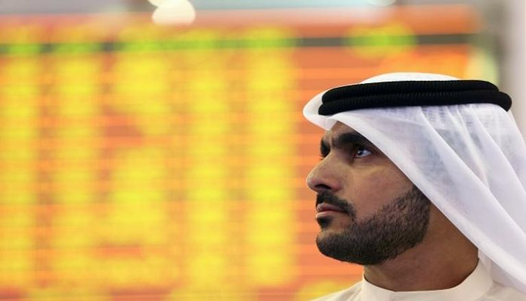 مستثمر يراقب شاشة التداول في سوق دبي المالي