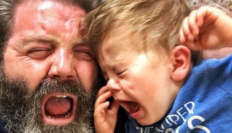 طفل يبكي بينما يقلده والده