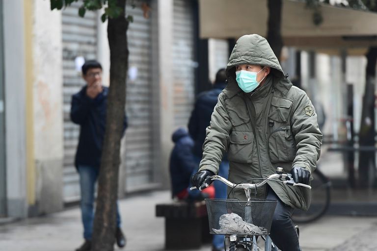 شاب وفتاة يتجولان مرتديان الكمامة للوقاية من كورونا