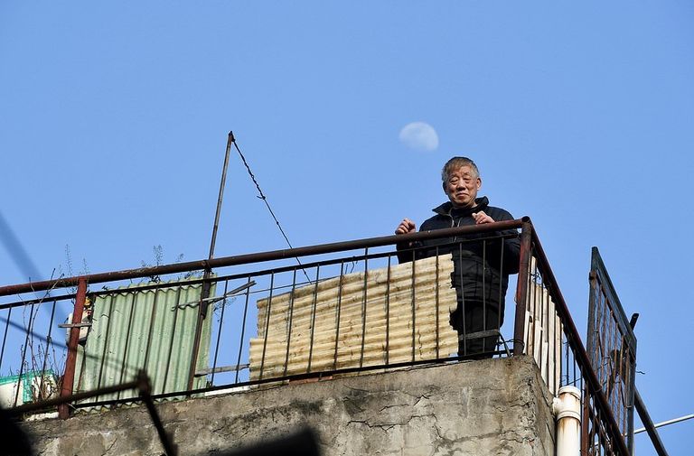 أحد سكان المدينة أثناء تناوله وجبة الغداء من شرفة منزله