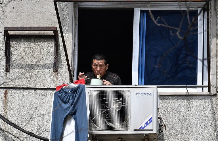 أحد سكان المدينة أثناء تناوله وجبة الغداء من شرفة منزله