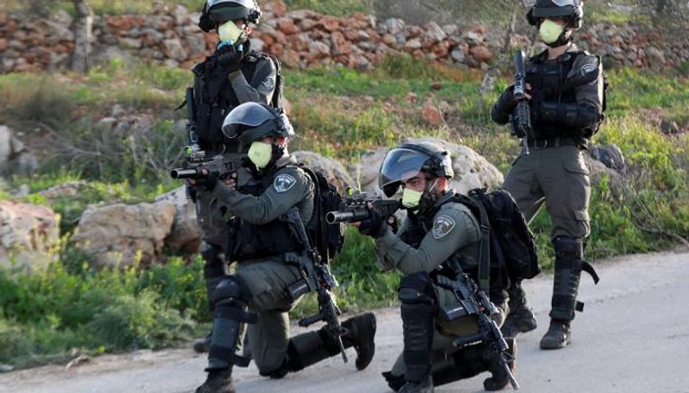 جنود من حرس الحدود الإسرائيلي يرتدون الكمامة خلال تصويبهم على فلسطينيين بالضفة الغربية