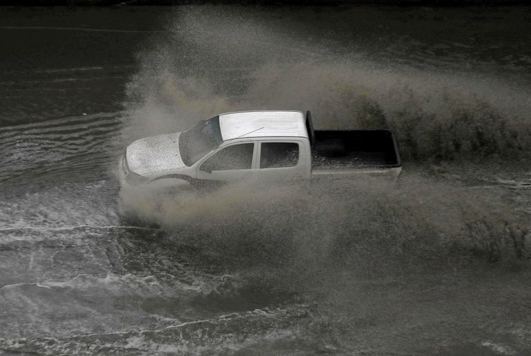 مصريان يركبان دراجة نارية خلال عاصفة رعدية وأمطار غزيرة في وسط القاهرة