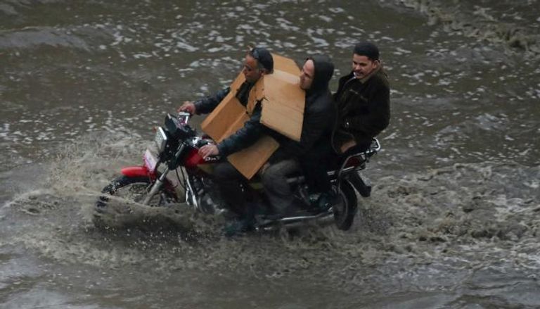 مواطنون يركبون دراجة نارية بأحد شوارع القاهرة